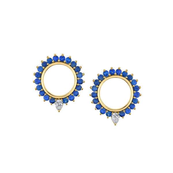 18k yellow gold stud earrings in the shape of a circle with an open center. Stones are blue sapphire around the circle with a pear shaped white diamond at the bottom center