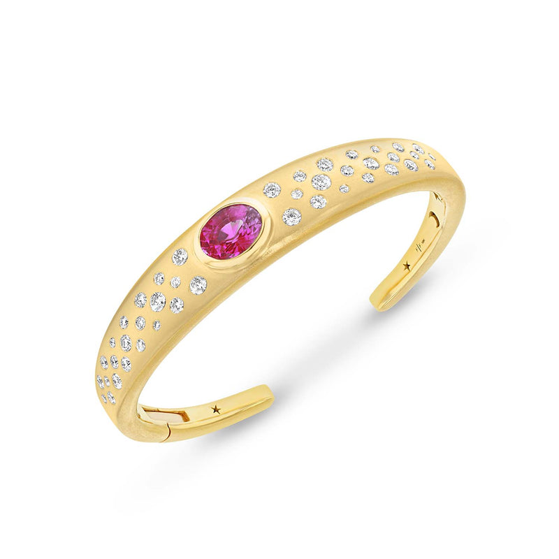 18k yellow gold cuff bracelet with an oval shaped pink tourmaline center stone with scattered white diamonds